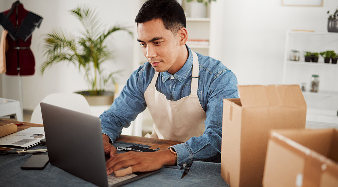 employee at a fashion design business working at a computer