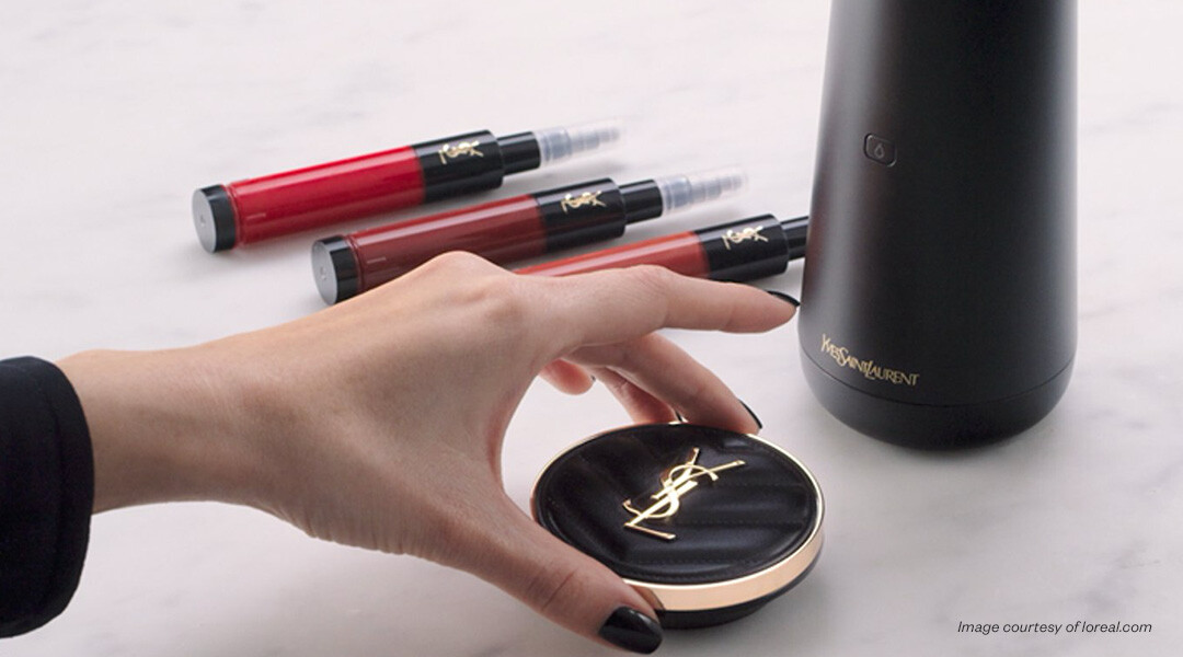 image of hand holding a YSL compact at a table of YSL beauty products